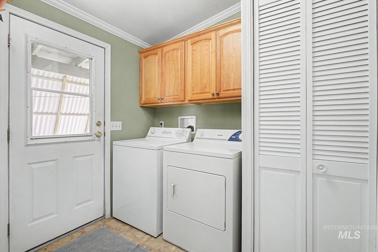1480 Birch Street Clarkston, WA 99403 - Photo 14 of 30 Laundry area with cabinet space, ornamental molding, and separate washer and dryer