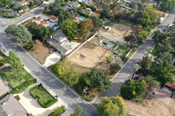 an aerial view of a house with a yard and greenery