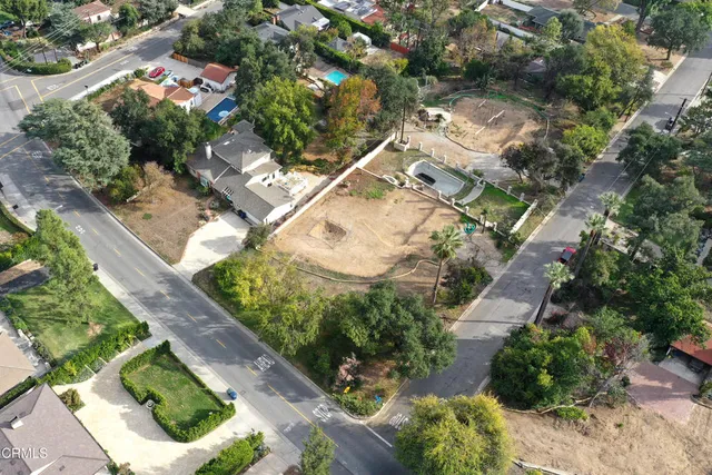 an aerial view of a house with a yard and greenery