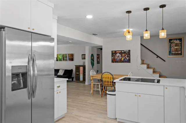 a view of living room with kitchen island stainless steel appliances furniture a fireplace and a sink