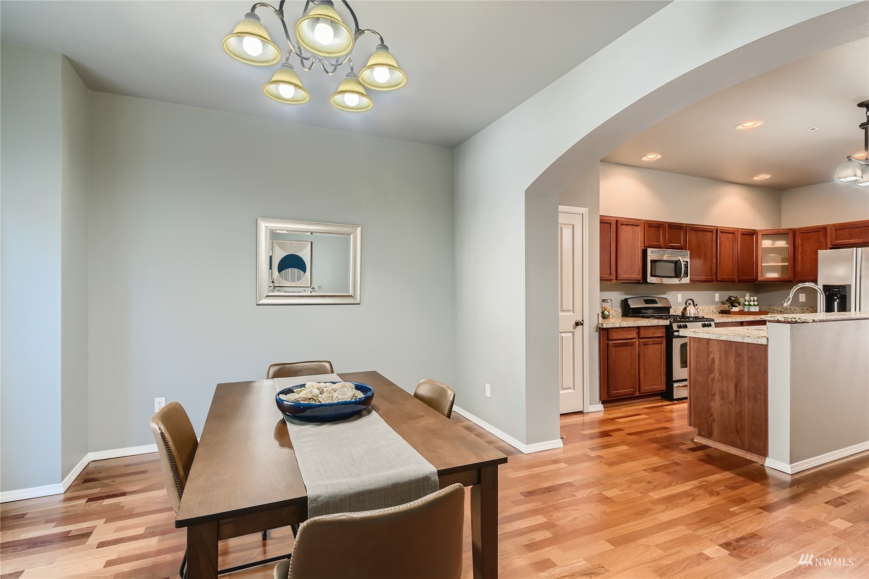 1054 215th Place Southeast Bothell, WA 98021 - Photo 7 of 28 a open kitchen with stainless steel appliances granite countertop a stove a refrigerator a kitchen island a sink with a dining table and chairs