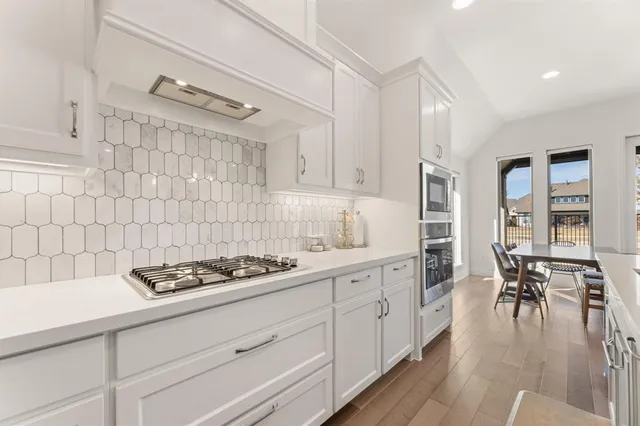 a large kitchen with kitchen island a dining table and chairs