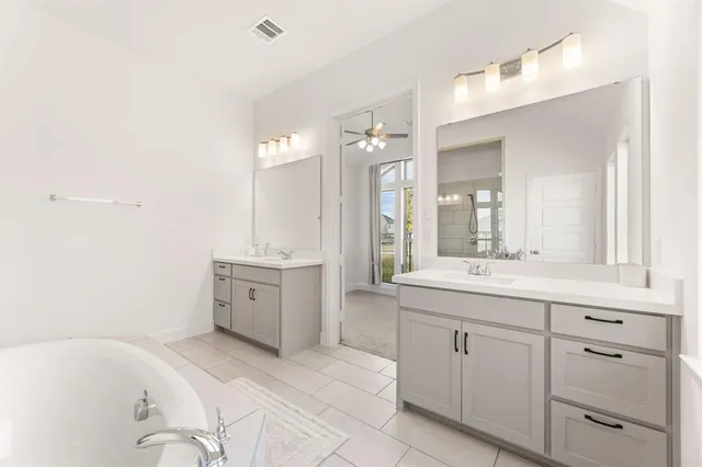 a bathroom with a tub sink and mirror
