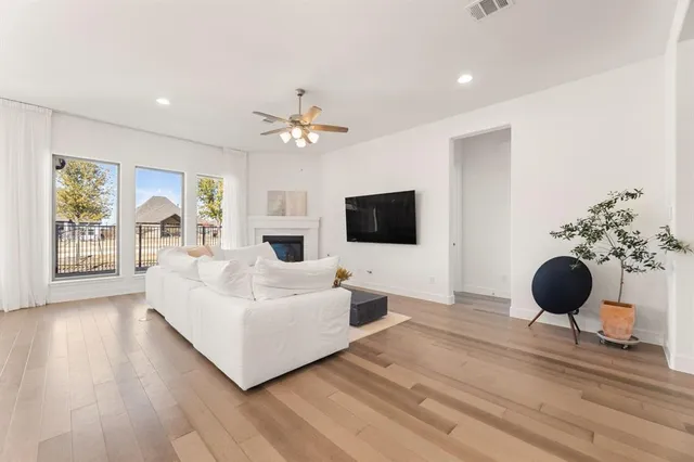 a living room with furniture a flat screen tv and a large window
