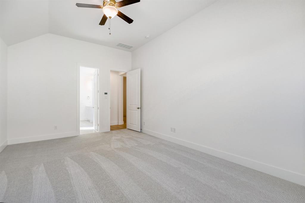 180 Buffalo Boulevard Rhome, TX 76078 - Photo 10 of 28 an empty room with a ceiling fan and carpet