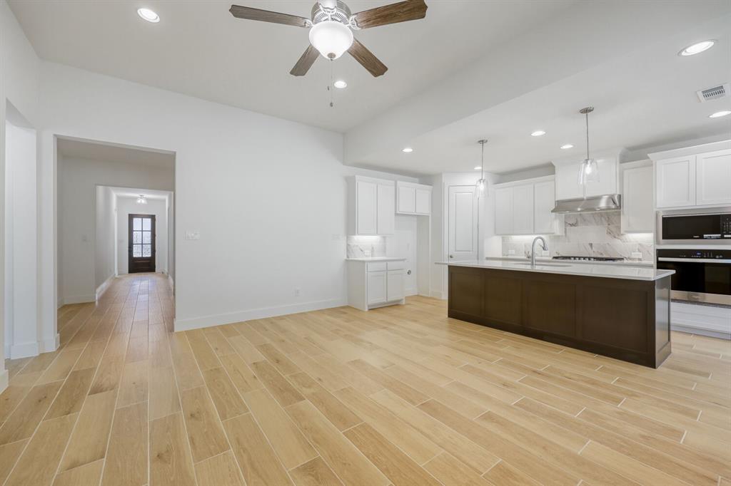 180 Buffalo Boulevard Rhome, TX 76078 - Photo 28 of 28 a view of kitchen with kitchen island stainless steel appliances wooden floor cabinets and window