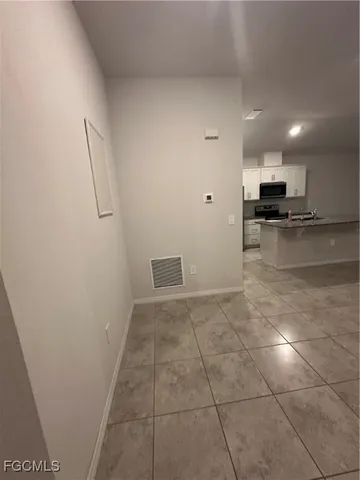 a view of a kitchen with kitchen island microwave and cabinets