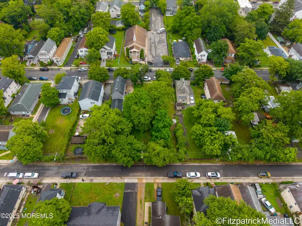 an aerial view of residential house with outdoor space and trees all around