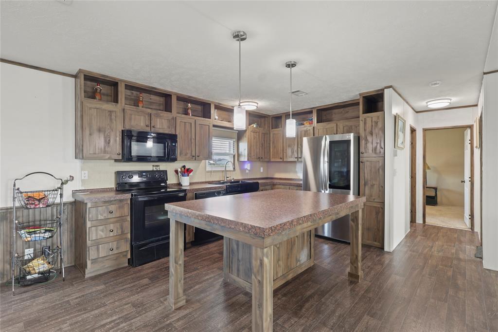 10240 Norrell Road Venus, TX 76084 - Photo 14 of 38 Kitchen with black appliances, hanging light fixtures, a kitchen island, dark wood-type flooring, and open shelves
