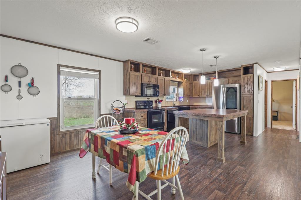10240 Norrell Road Venus, TX 76084 - Photo 18 of 38 Dining space featuring dark wood finished floors, a textured ceiling, and wood walls