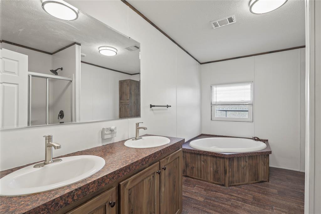 10240 Norrell Road Venus, TX 76084 - Photo 22 of 38 Bathroom featuring a textured ceiling, ornamental molding, double vanity, a stall shower, and dark wood-style floors