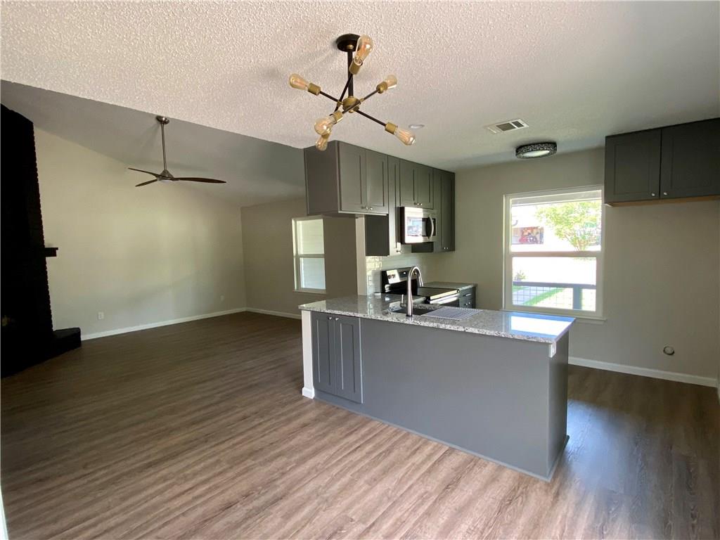 1715 Shadowview Drive, Unit B Austin, TX 78758 - Photo 14 of 28 A well-appointed kitchen island with sleek cabinetry defines this inviting open-concept living space.