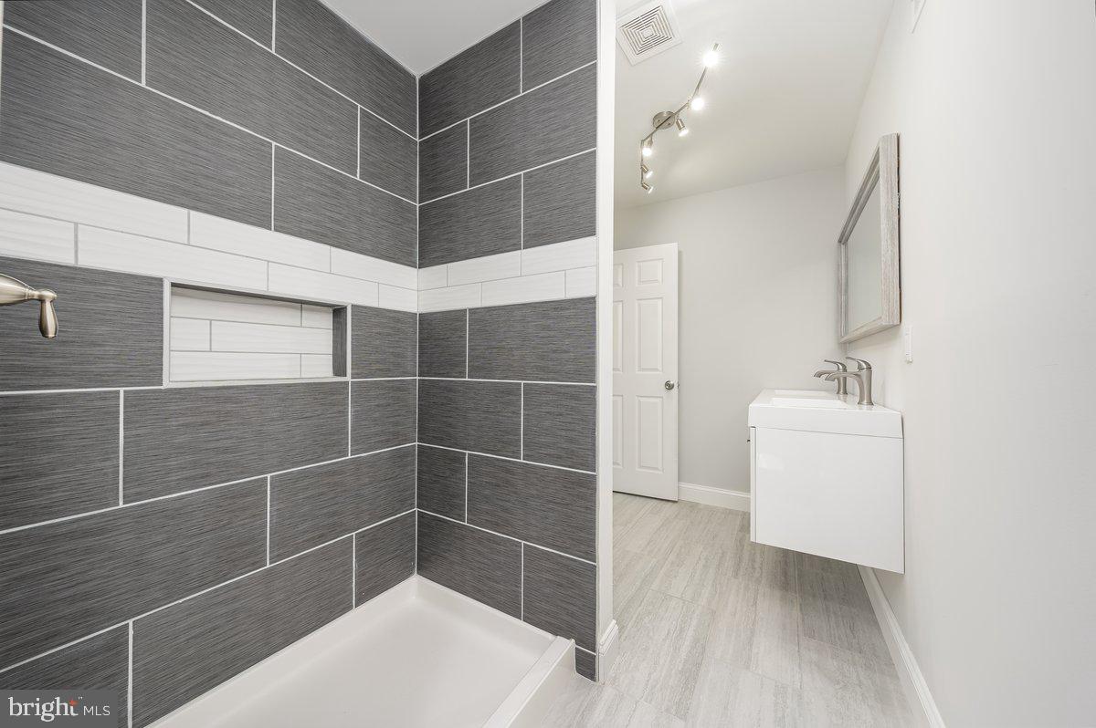 523 East 20th Street Baltimore, MD 21218 - Photo 15 of 28 a bathroom with a bathtub and a sink