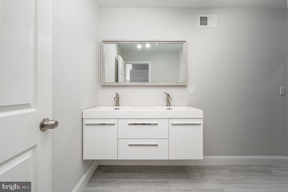 523 East 20th Street Baltimore, MD 21218 - Photo 16 of 28 a bathroom with a sink vanity and mirror