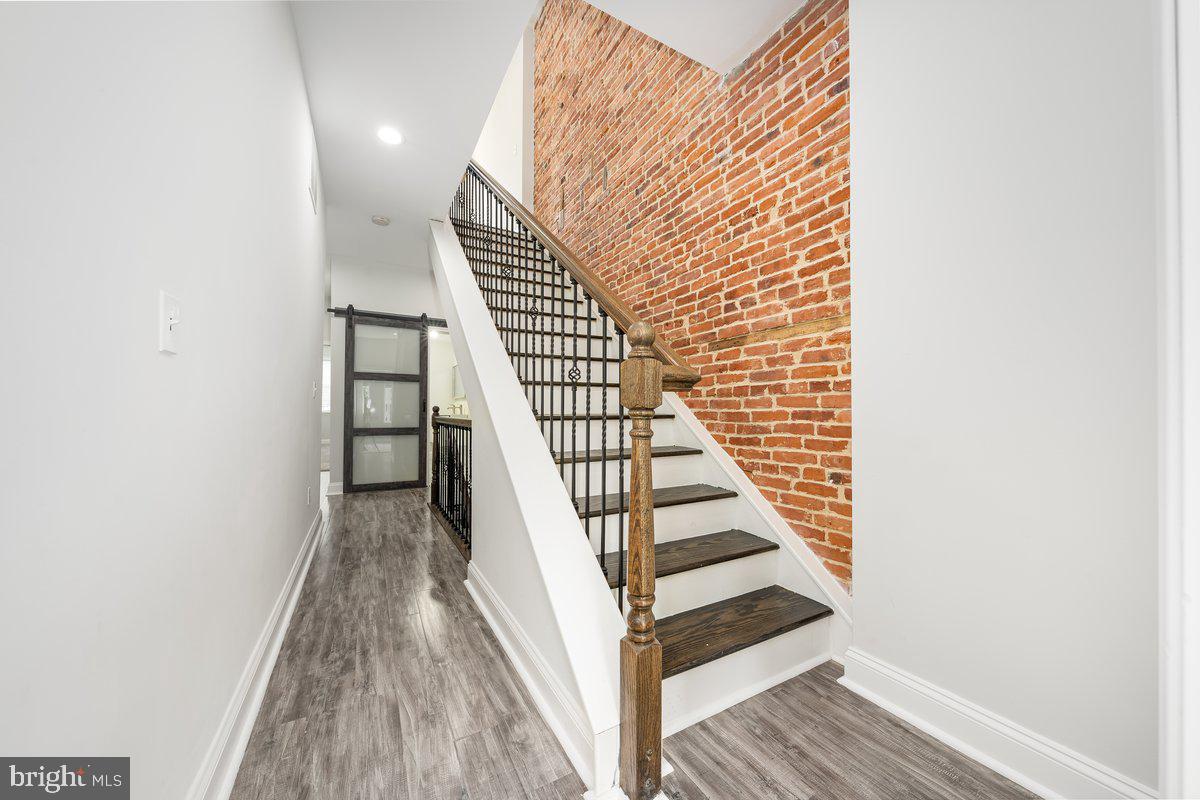 523 East 20th Street Baltimore, MD 21218 - Photo 17 of 28 a view of a hallway with wooden floor and staircase