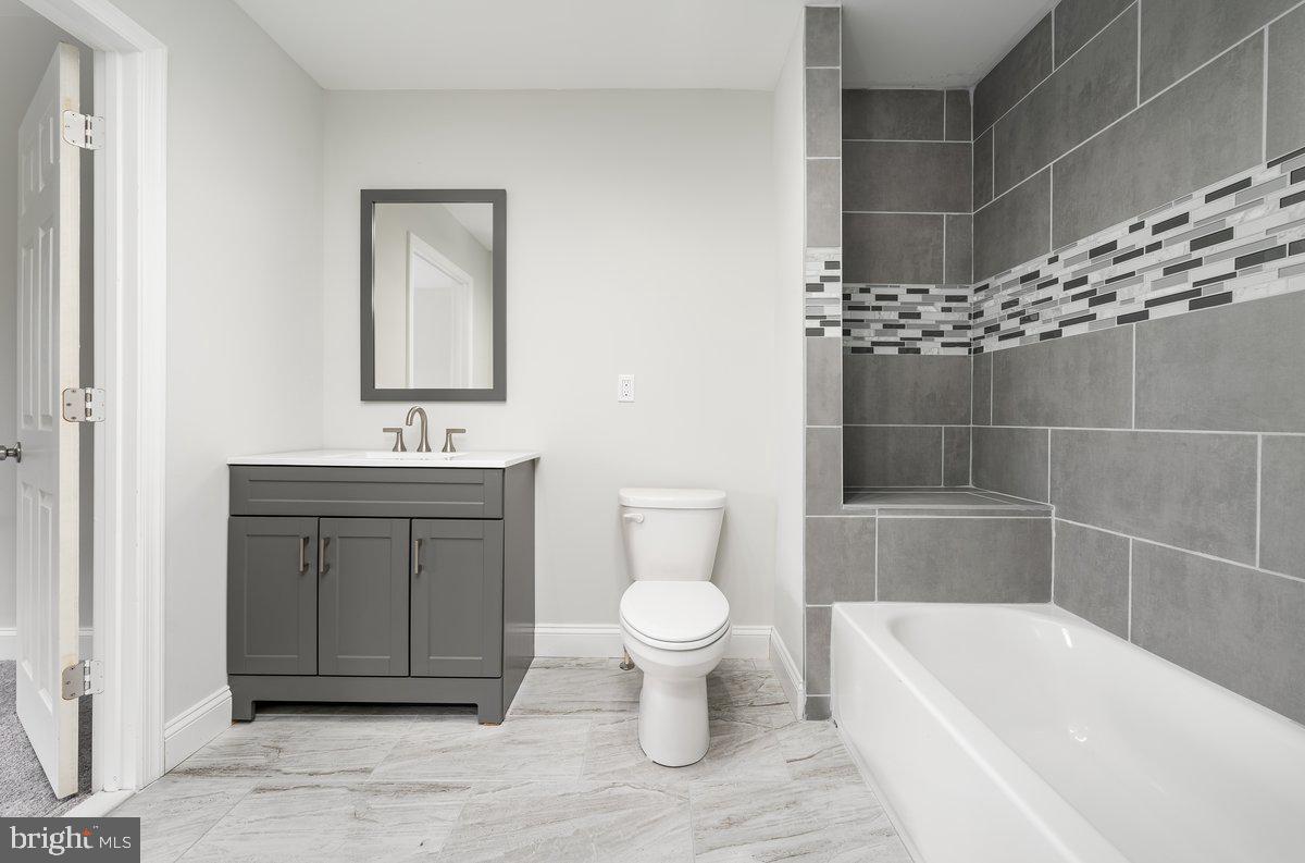 523 East 20th Street Baltimore, MD 21218 - Photo 20 of 28 a bathroom with a sink a toilet and shower