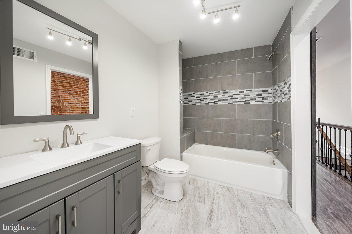 523 East 20th Street Baltimore, MD 21218 - Photo 21 of 28 a white bath tub sitting next to a white toilet