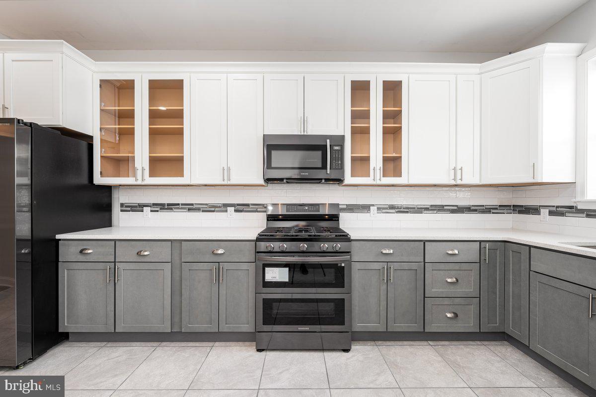 523 East 20th Street Baltimore, MD 21218 - Photo 4 of 28 a kitchen with stainless steel appliances granite countertop a stove and a refrigerator