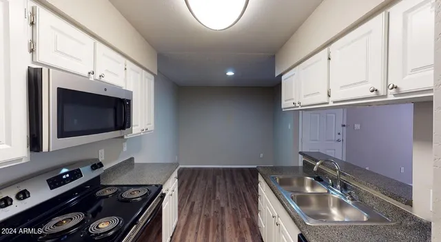 a kitchen with a sink a microwave and cabinets