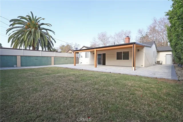 a front view of house with yard and trees in the background