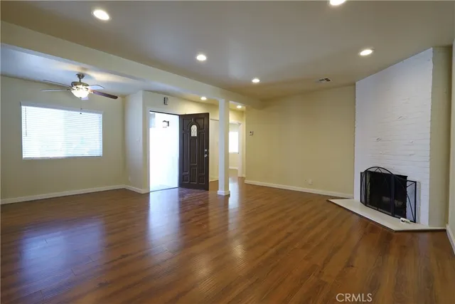 an empty room with wooden floor and fireplace