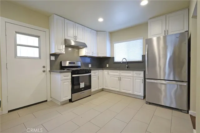 a kitchen with a refrigerator sink and cabinets