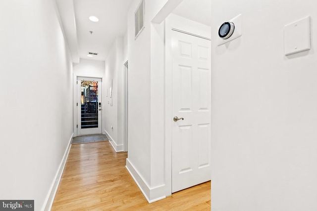 a view of a hallway with wooden floor and closet