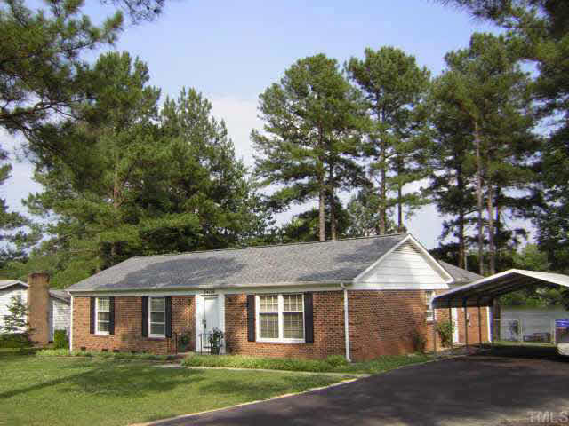 5409 Pelham Road Durham, NC 27713 - Photo 1 of 10 Front elevation, carports, yard, and lake Exterior Front