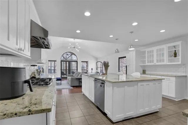 a kitchen with stainless steel appliances granite countertop a refrigerator and a sink