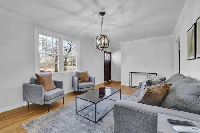 a living room with furniture a large window and a chandelier