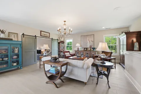 a living room with furniture a fireplace and a floor to ceiling window
