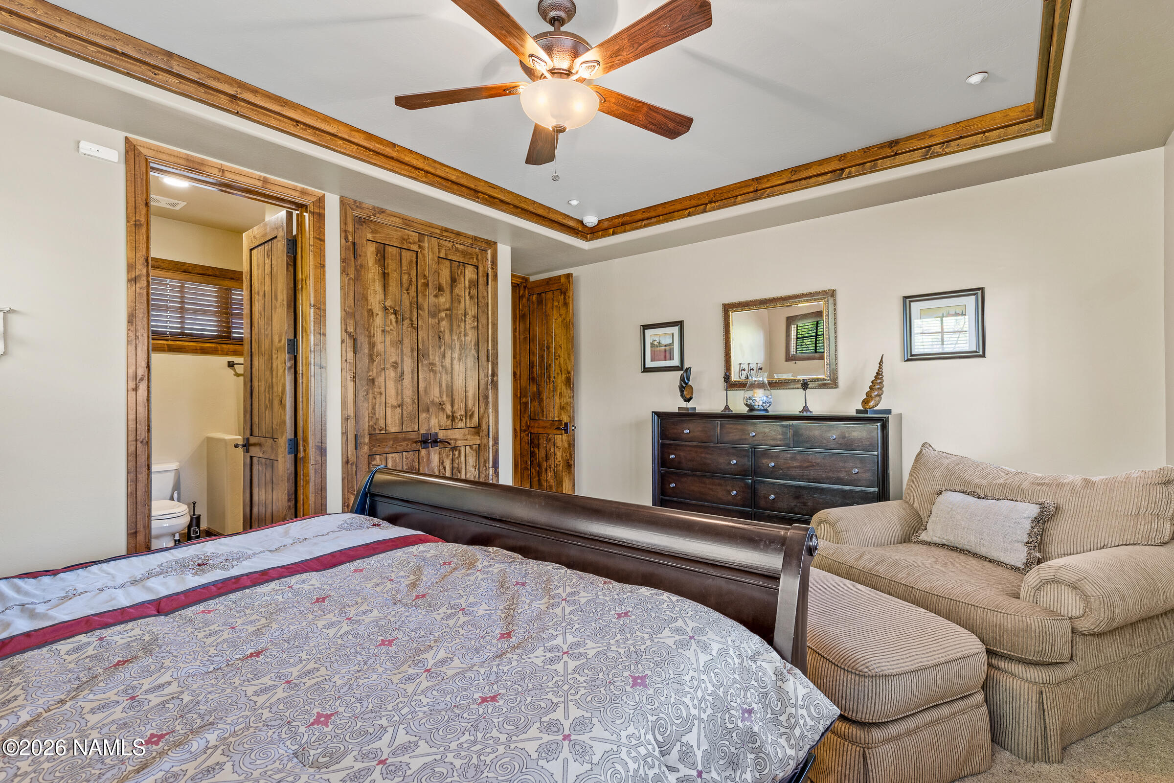 2214 East Del Rae Drive Flagstaff, AZ 86005 - Photo 26 of 45 a bedroom with a large bed and a chandelier
