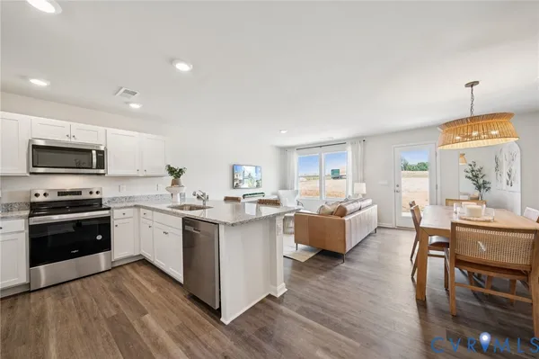 a kitchen with stainless steel appliances granite countertop wooden floors and view living room