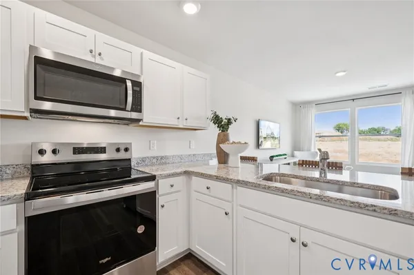 a kitchen with granite countertop a sink and steel stove