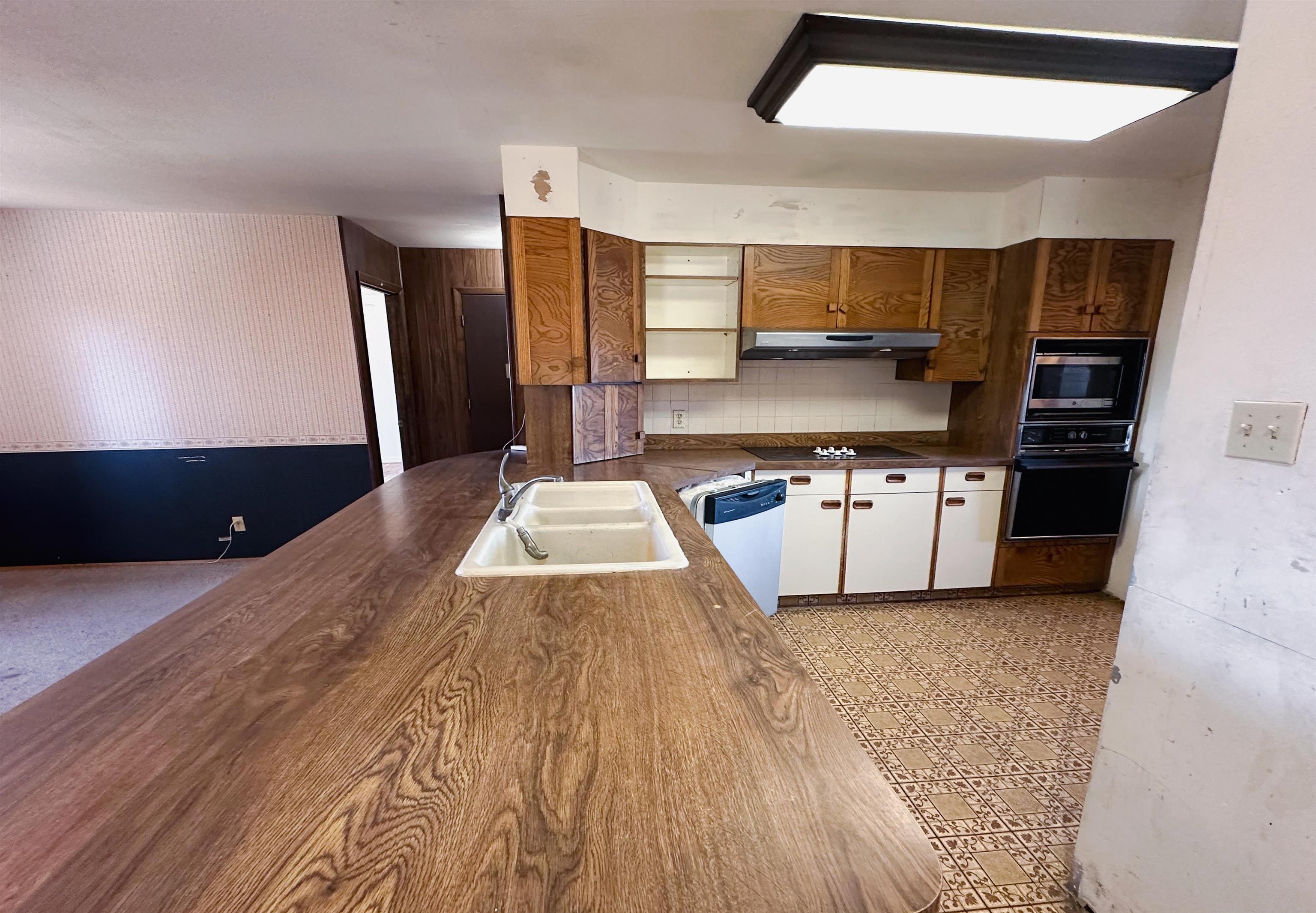 1818 County Road 46 Rangely, CO 81648 - Photo 8 of 23 a kitchen with stainless steel appliances a stove a sink and white cabinets