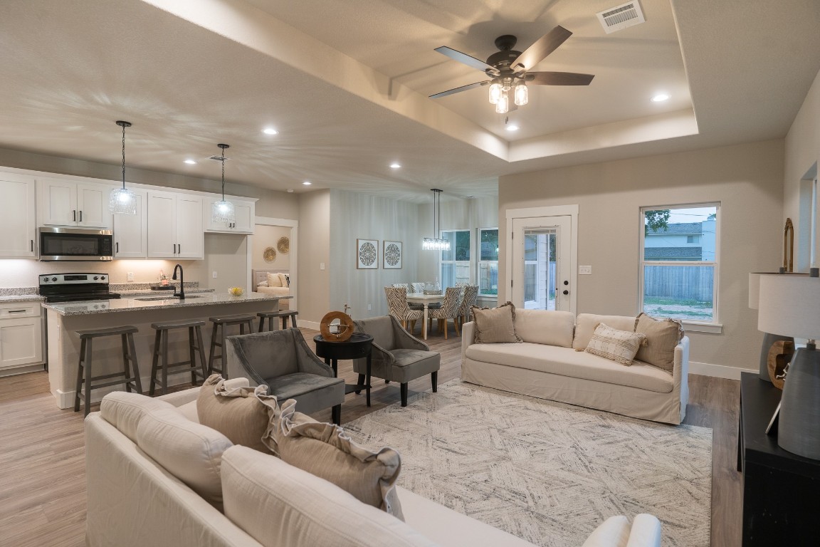 307 String Prairie Way Smithville, TX 78957 - Photo 15 of 34 Living area featuring light wood finished floors, recessed lighting, ceiling fan, a raised ceiling, and baseboards