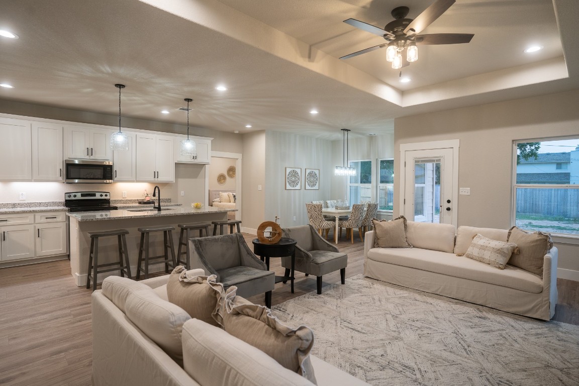307 String Prairie Way Smithville, TX 78957 - Photo 16 of 34 Living room with recessed lighting, light wood finished floors, a ceiling fan, and a tray ceiling