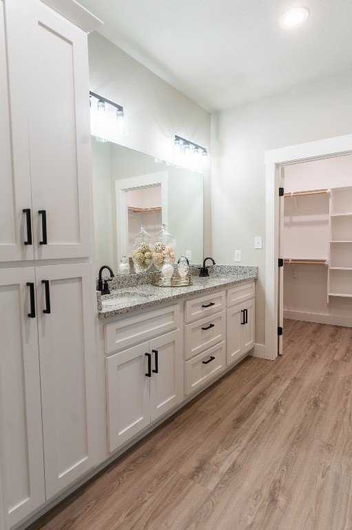 307 String Prairie Way Smithville, TX 78957 - Photo 25 of 34 Bathroom with double vanity, wood finished floors, and recessed lighting