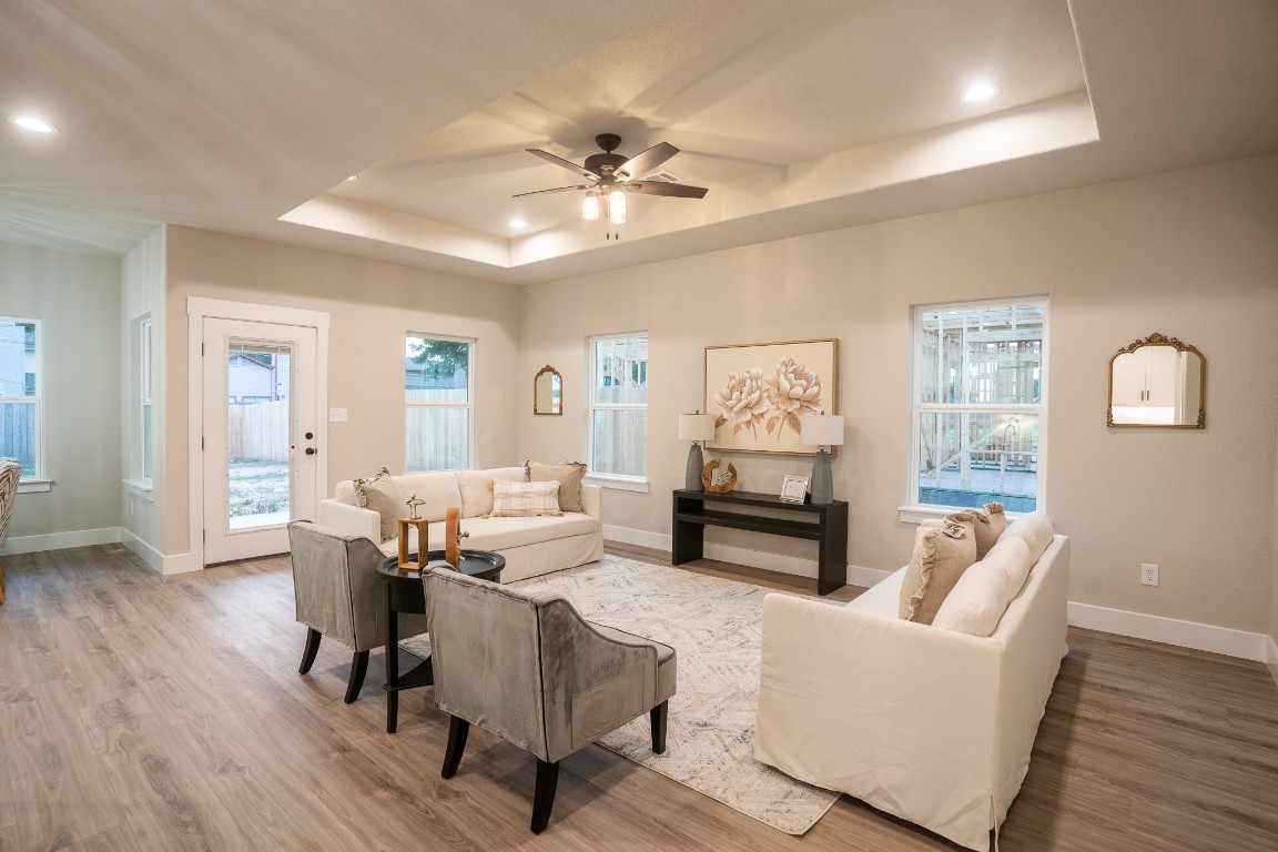 307 String Prairie Way Smithville, TX 78957 - Photo 9 of 34 Living room with a raised ceiling, wood finished floors, baseboards, ceiling fan, and recessed lighting