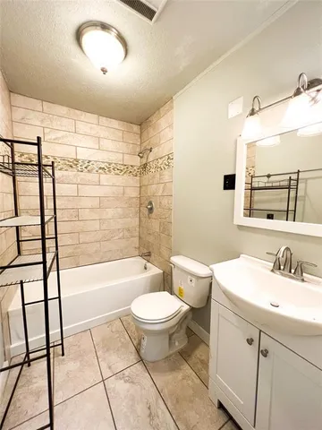 a bathroom with a bathtub shower sink vanity mirror and toilet