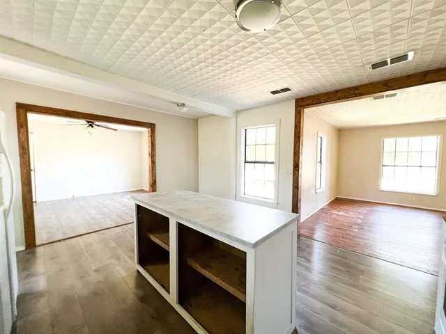 a hallway with a large window appliances and cabinets