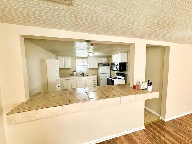 a kitchen with white cabinets and appliances