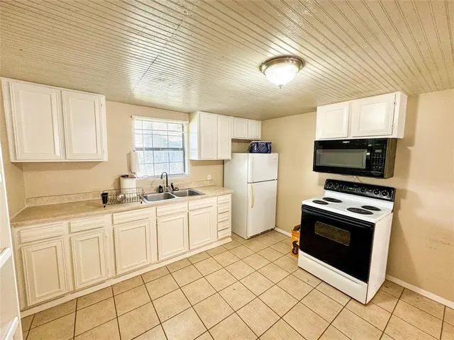 a kitchen with a sink a stove and cabinets