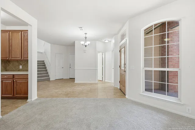 an empty room with windows and cabinet