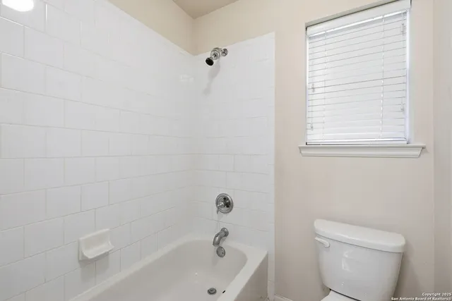a white bath tub sitting next to a toilet