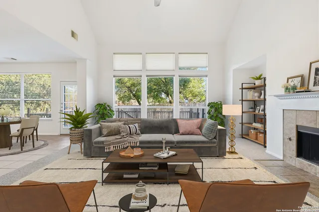a living room with furniture a fireplace and a large window