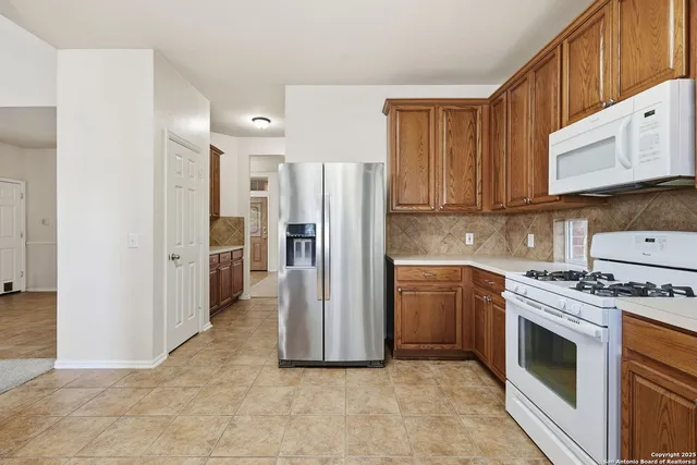 a kitchen with a stove top oven and refrigerator
