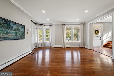 a view of a dining room with furniture a chandelier and wooden floor