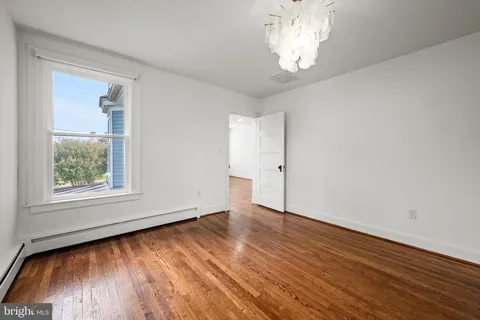 a view of empty room with wooden floor