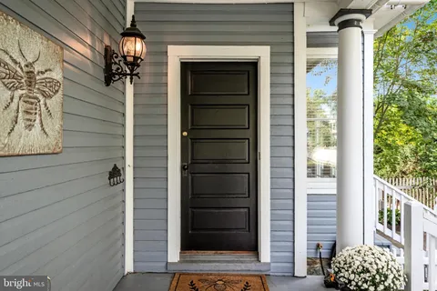 a view of a brick house with a porch and furniture